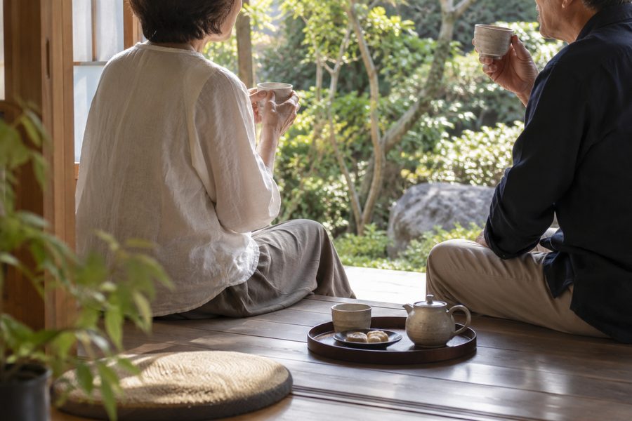 縁側でお茶を飲みながら庭を眺める二人